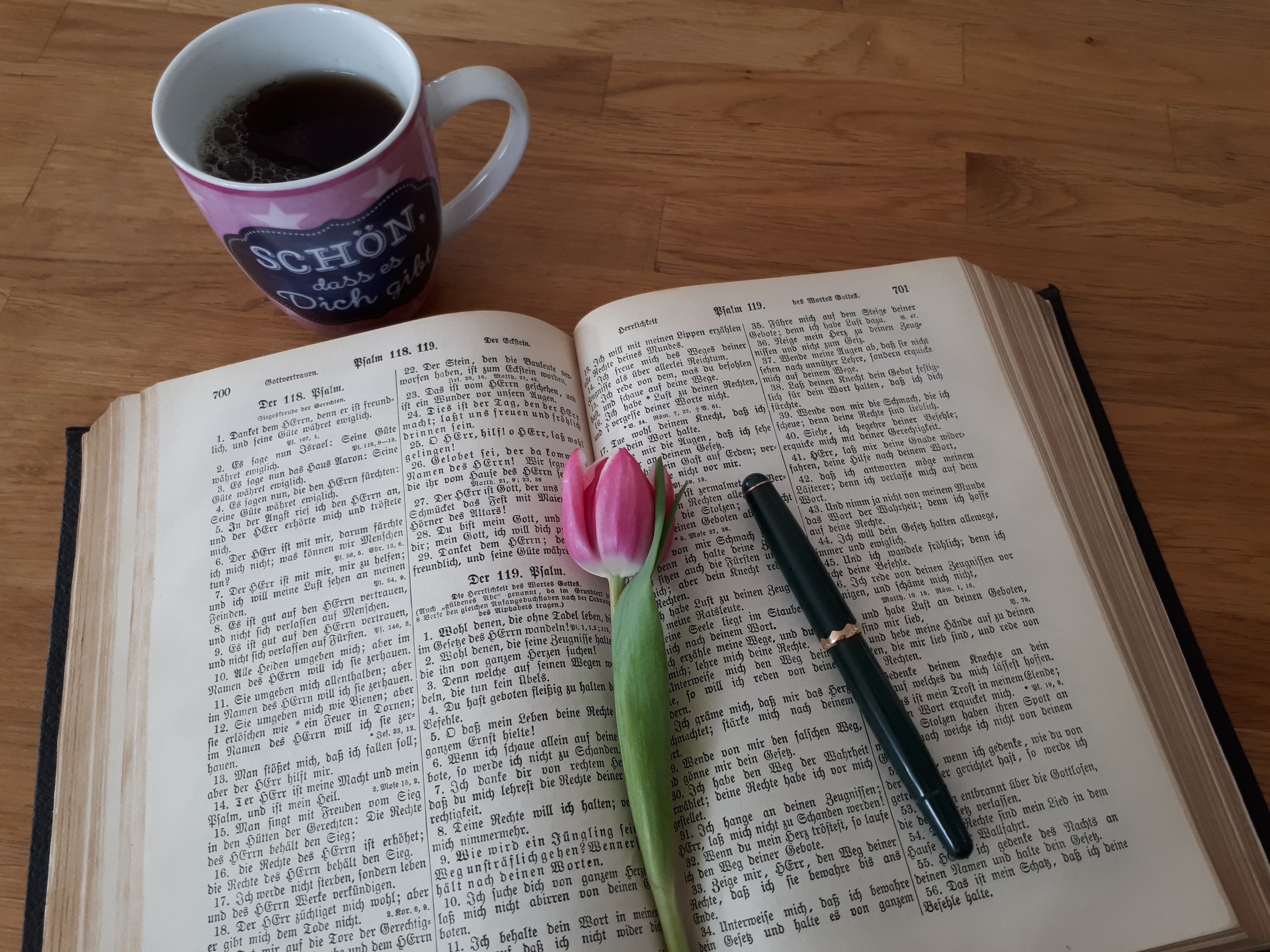 Aufgeschlagene Bibel mit Tulpe und Kaffeetasse