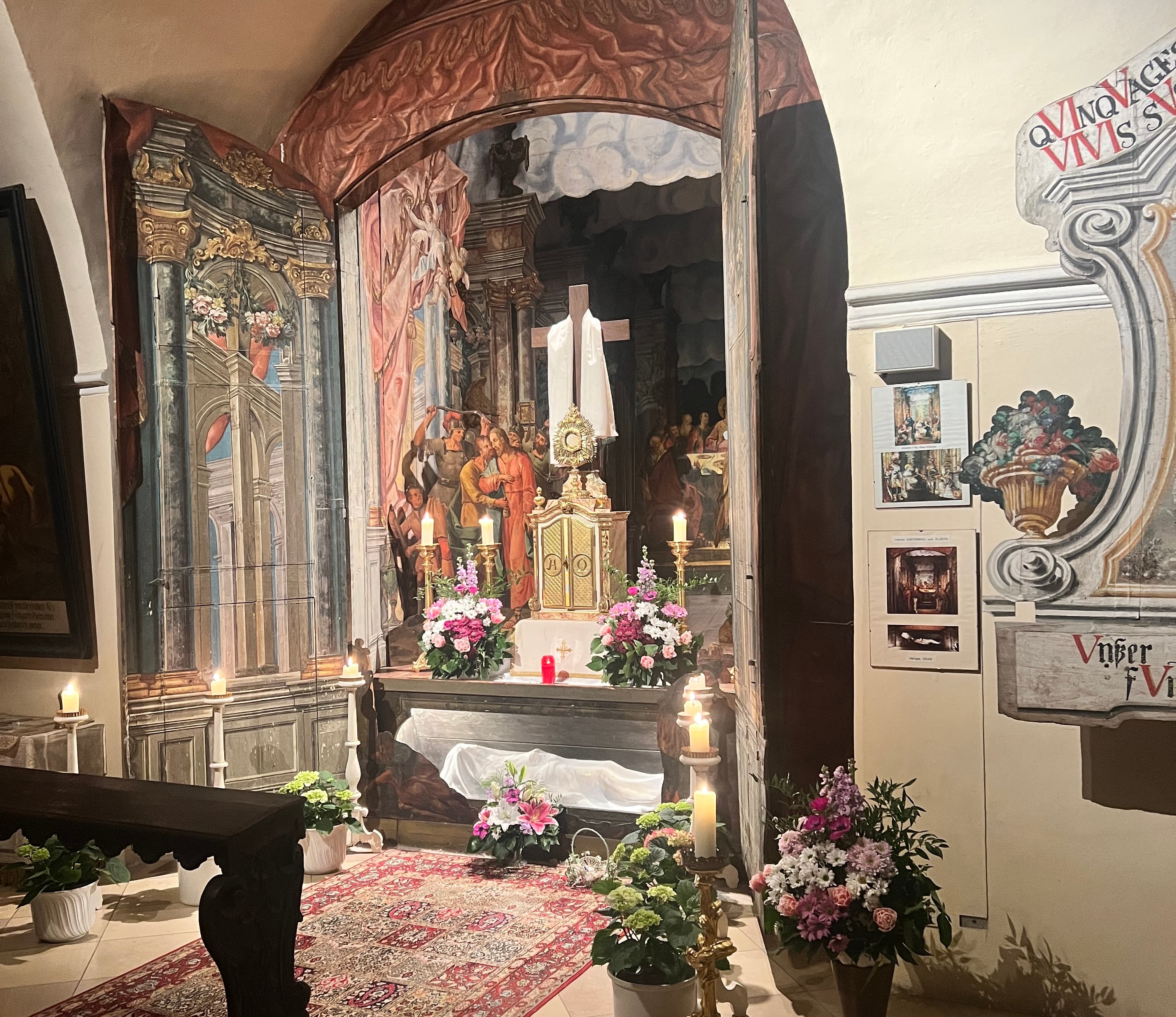 Ein barocker Seitenaltar mit Blumen und Kerzen